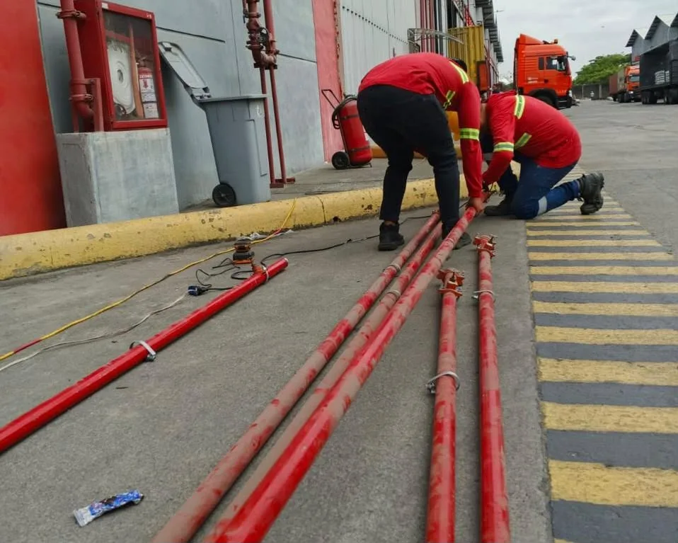 Técnicos tendiendo tuberías CI rojas en piso